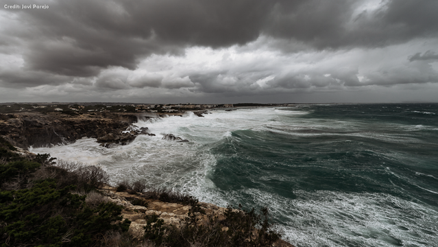 Seesturm. Formentera. Spujols Strand: Schwere See brandet an die Küste. Dunkelgraue schwere Gewitterwolken in fahlem Licht am Himmel.

Credit: Javi Parejo