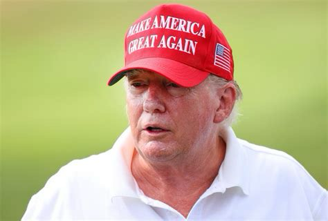 Picture of a silly looking Donald Trump with a red MAGA hat and without makeup.