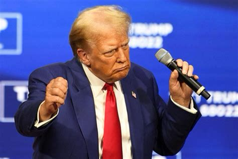 Picture of a silly looking Donald Trump with orange skin dancing on stage with a microphone in his hand.