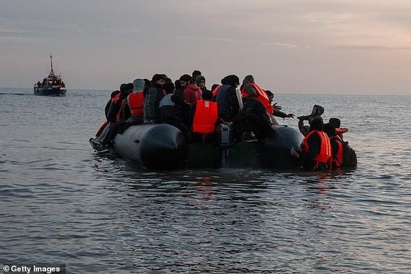 A boy is lifted onto a migrant dinghy as a French rescue vessel watches on, on May 31, 2025 in Gravelines, France