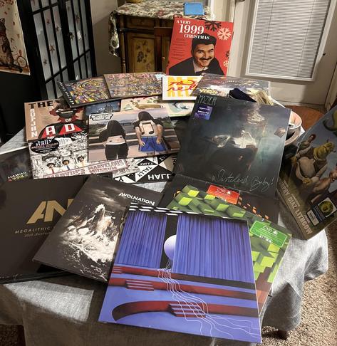 A photo of various vinyls laying on a table.

From front to back:
Digital Nightmare by TWRP
Run & Megalithic Symphony by AWOLNATION
Minecraft Volume Alpha & Beta by C418
Wasteland, Baby! by Hozier
Shrek Soundtrack by the ogre himself
Hawaii: Part II by Miracle Musical
Marvin’s Marvelous Mechanical Museum & ‘Good & Evil’ by Tally Hall
10,000 gecs by 100 gecs
The Age of Adz, Illinoise, Michigan, The Ascension & Javelin by Sufjan Stevens
New Release by YACHT
A Hat in Time Vol. 2 by Pascal Michael Stiefel
A Very 1999 Christmas by jshlatt