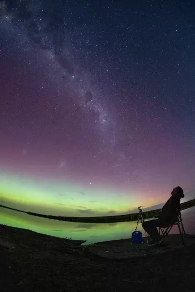 A man takes photographs of aurora australis on the horizon over Lake Ellesmere in Lincoln on the outskirts of Christchurch.
