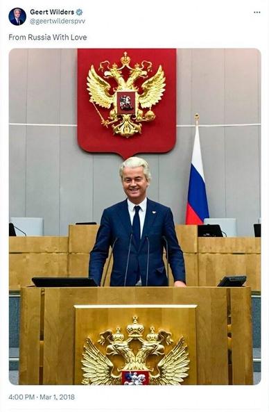 Tweet by Geert Wilders. Dated: 1 March 2018.
Pictured is himself standing in the Russian Duma, on the speaker’s platform adorned with the Russian sigil. Hanging on the wall behind him, is another Russian sigil. Next to it sits a Russian flag.
He writes:
“From Russia With Love”