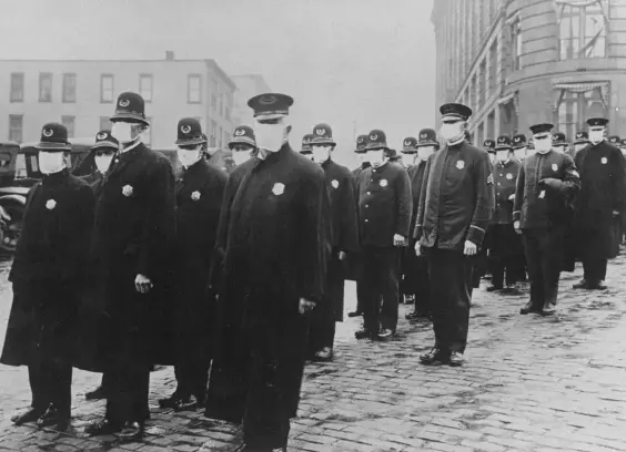 In a 1918 photo for Life Magazine, Seattle policemen stand in the street wearing protective face masks.