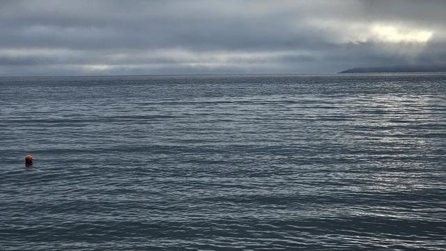 A heavily overcast sky above a calm sea.
