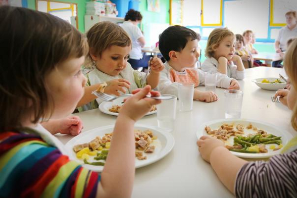 Photo: primary school children eating their lunchtime meals.