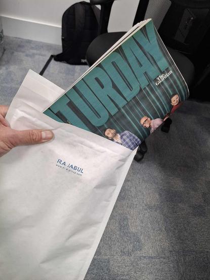 a folded over Guardian Saturday magazine sticking out of a white envelope.