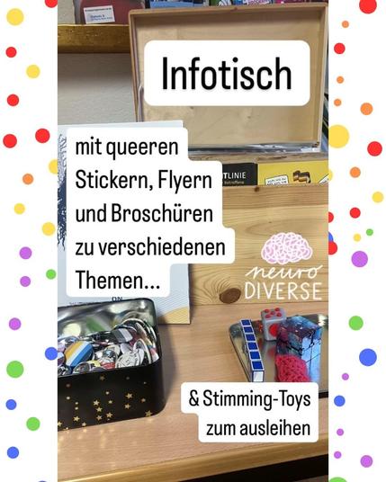 Das Bild zeigt einen Tisch mit Stimmig Toys, Buttons und Infomaterial, sowie den Text: "Infotisch: mit queeren Stickern, Flyern und Broschüren zu verschiedenen Themen... & Stimming-Toys zum ausleihen."