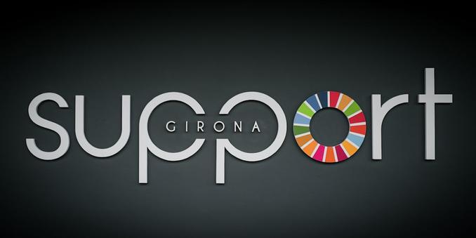 Stylised writing stating "Support Girona".