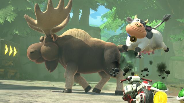 Cow looking like she is jumping off her bike to get to the huge moose.