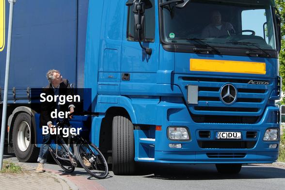 Bearbeitung eines Fotos von Jens Lehmkühler (ADFC), Lkw-Fahrer biegt rechts ab, direkt daneben auf einem Radweg ein Radfahrer, der sein Rad zur Seite zieht, Lkw-Kennzeichen beschriftet mit "(C)DU", Beschriftung des Radfahrers: "Sorgen der Bürger"