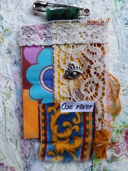 Talisman "Ose rever" (dare to dream) in fabrics from the early 1970s, with lot's of white lace and an egyptian eye in silver.