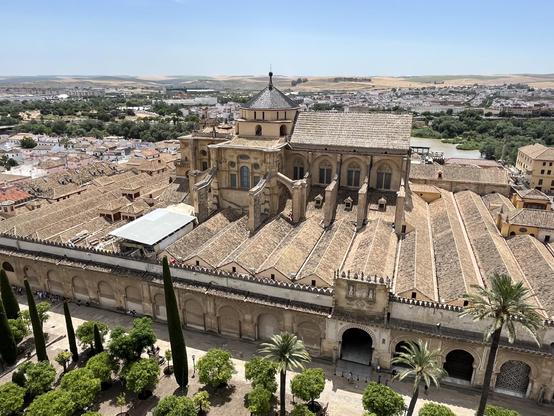 Bird's eye view of the Mezquita-Cathedral in Córdoba showing a cathedral building rising in the middle above the mosque's roof.