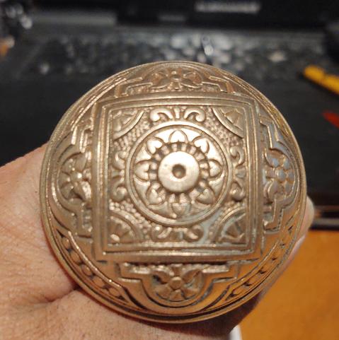 A beautiful brass Eastlake doorknob with four way symmetry mostly cleaned and polished. There's a little bit left to do.