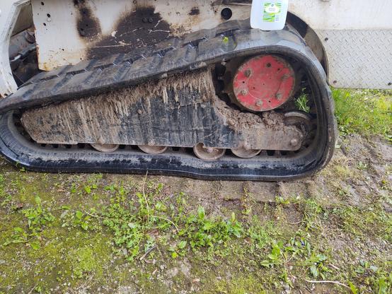 A bobcat excavator, showing the rubber track. One of the rollers has broken out of the steel plate that makes up the side of the machine. This shouldn't happen. It takes an extra special kind of dumb to break something this way. Whatever, I fixed it.