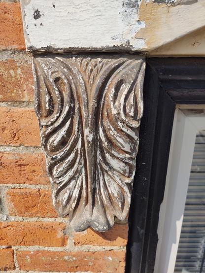 Before image of cast iron window trim with rust and white paint.