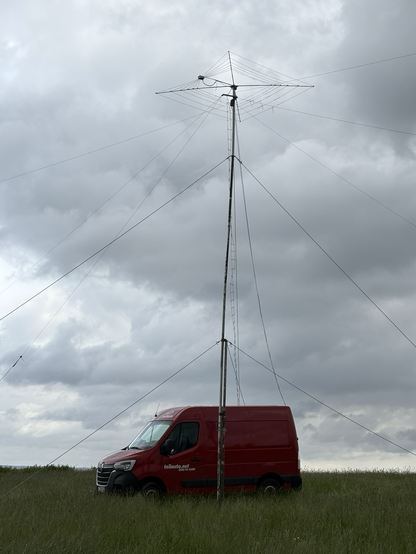 A transporter with a large pole attached and shortwave wire antennas