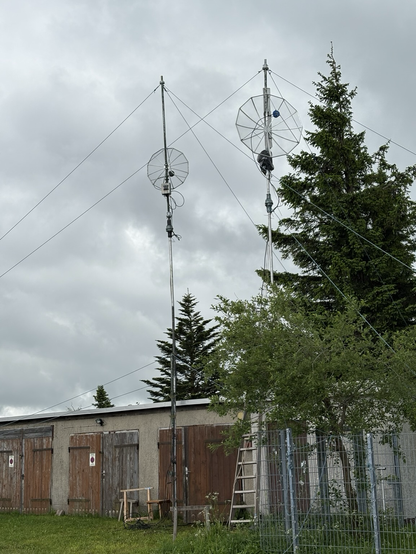 Two parabolic antenna in front of a garage