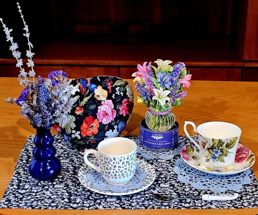 Tea tableau with a riotous display of flowers, real ones as well as imprinted on fabrics, china, and paper. The tea is Lavender Earl Grey black loose-leaf.