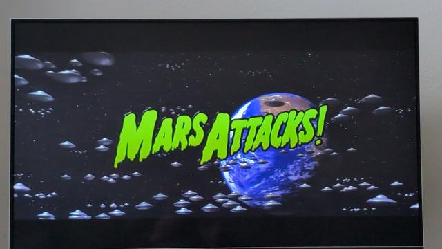 Ufos fliegen auf die Erde zu.
Davor in grün der Titel "Mars Attacks"
