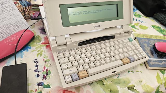 A photo of a luggable machine from the mid nineties. It's a canon star writer jet three hundred. What is it? It looks like an electric typewriter with extra gubbins. A small flip up lid display with a keyboard below (a gorgeous keyboard to use, by the by), and a long protruding bum containing an in-built printer. Some kind of dot matrix thing. I love it.