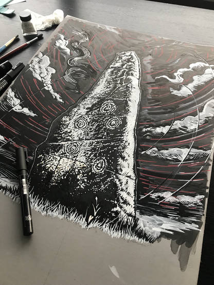 black & white, reversed design showing a standing stone covered in cup and ring marks against a dark sky with circling clouds. A pen sits on top of the lino