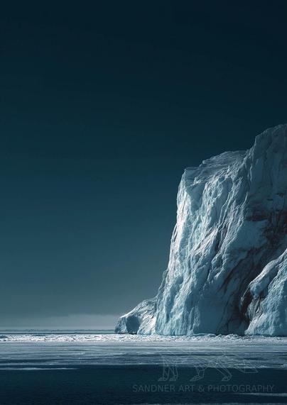 A towering glacier wall rises from a frozen, icy sea under a dark polar sky in Antarctica. The ice face is sculpted with intricate cracks and ridges, catching soft side light that highlights its texture and depth. The vast expanse of flat, frozen ocean stretches into the distance, while the sky above fades from a deep navy at the top to a paler gradient near the horizon, emphasizing the stark isolation and minimalist beauty of the polar landscape.