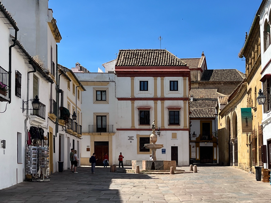 Photo of Córdoba's Plaza del Proto, a small place flanked by old Andalucian houses, with a little fountain, crowned by a horse figure, in the centre.