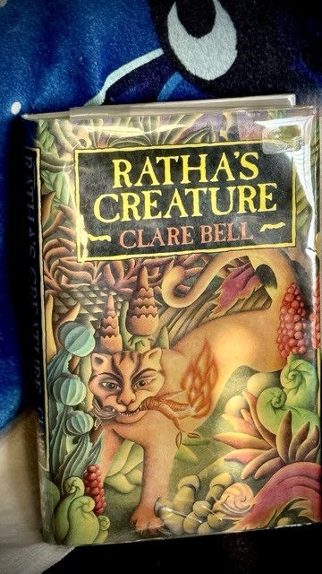 Ratha's Creature by Clare Bell. Shows a lion/leopard like cat with a stick of fire in her mouth. The graphic greatly matches a scene from the story.