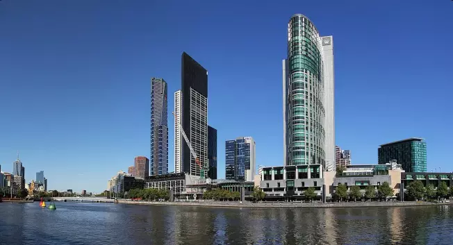 The image depicts a skyline of a city with modern skyscrapers and buildings along a waterfront. There is clear blue sky above, and the scene reflects a vibrant urban environment, likely featuring mixed-use developments. The buildings show a variety of architectural styles and heights, contributing to a dynamic cityscape. The water in the foreground adds to the aesthetic appeal.

Image Credits: Wikimedia / Donaldytong / CC BY-SA 3.0