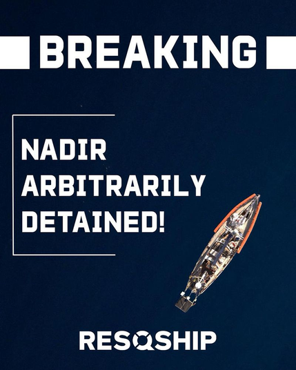 Die NADIR auf tiefblauem Meer senkrecht von oben aus der Luft aufgenommen.

Darüber in weiß:

BREAKING

NADIR ARBITRARILY DETAINED!

RESQSHIP