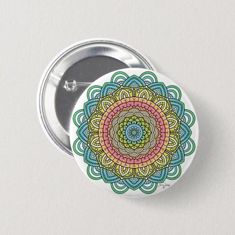 product image of a round pinback button with a pink-yellow-blue flower like mandala.
