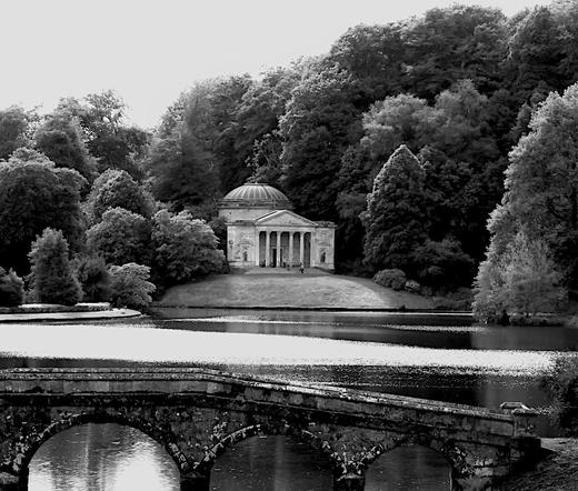 A temple, perhaps neo-palladian, that is an imitation of a classical Greek or Roman temple in the grounds of an English country house.
Dome at the back which is like the Pantheon, portico at the front facing this way. Also rather like the Pantheon.