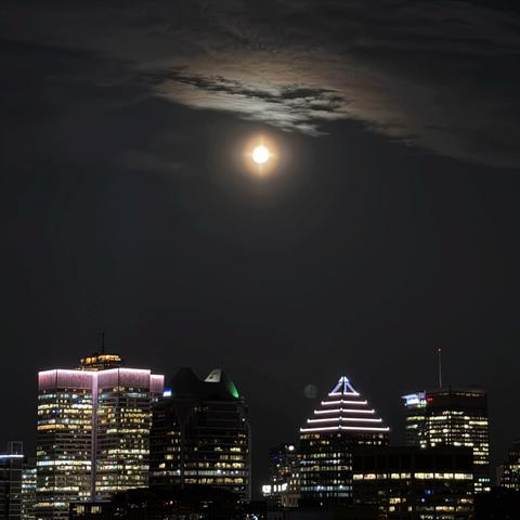 Downtown Montreal skyline with moon and clouds above