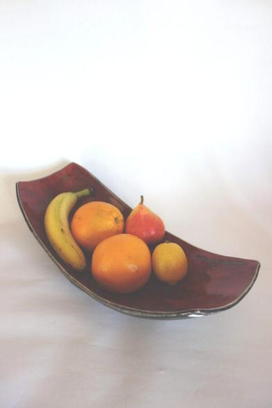 Rechteckige, längliche Keramikschale mit Obst (Banane, Orangen, Birne, Zitrone), oben dunkelrot glasiert, unten schwarz