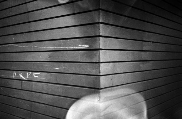 Bleached film, flawed view of the corner of a building nearby home. Taken on Lomography BW Earl Grey 100 analogue film using an Olympus XA-2 camera.
