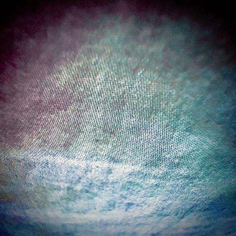 A spotlight of cloth fibers extends off into the distance in bright pinks, purples, greens, and blues.