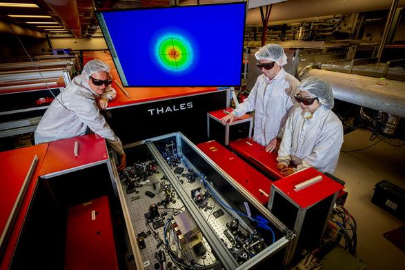 Three researchers align precision optics to prepare the Berkeley Lab Laser Accelerator (BELLA) Petawatt laser for laser-plasma accelerator experiments.