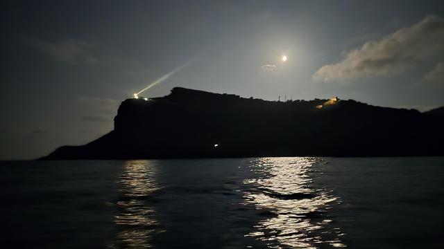 Vista di Ustica dal mare in una notte di luna piena.