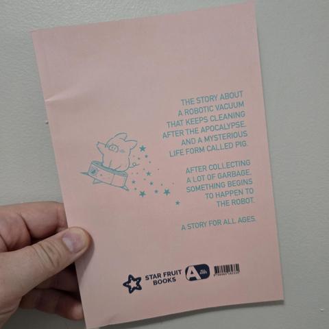 Image of a white person's hand holding the back cover of Doomsday Cleaning against a light colored wall. The image is all pink with largely light blue text and a light blue outlined image of a pig riding a self-propelled vacuum with stars behind it. Text on the cover reads, "The story of a robotic vacuum that keeps cleaning after the apocalypse and a mysterious life form called pig. After collecting a lot of garbage something begins to happen to the robot. A story for all ages."