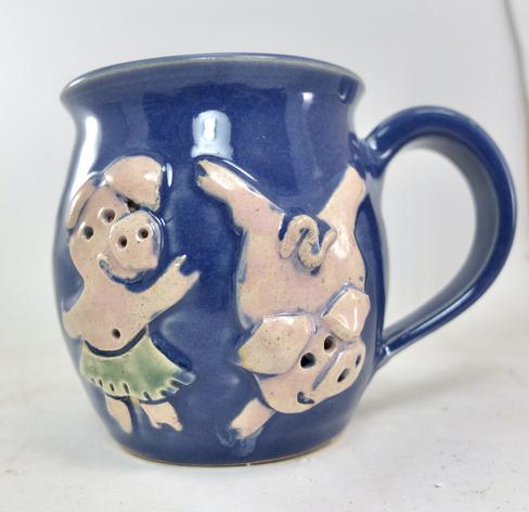 handmade mug with two dancing pigs in relief on the side
