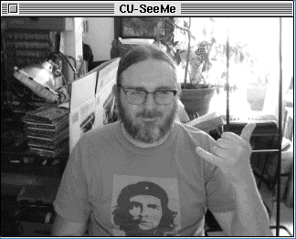 Screenshot of a faux CU-SeeMe window, emulating a Connectix QuickCam (320x240; 4-bit grayscale), in a Mac OS 7-like window, showing Morgan smiling in his home office.