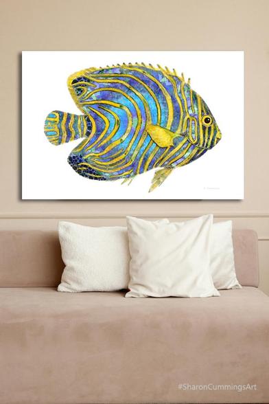 Blue and yellow tropical fish painting on white in a furniture setting by artist Sharon Cummings.