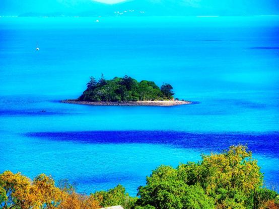 Blue ocean surrounding a small island off Hamilton Island, North Queensland
