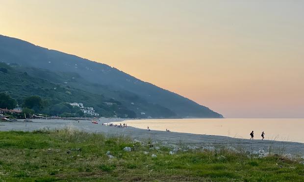 Evening light gives an orange glow to the sky above Chorefto Beach