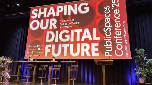 Stage with large projection screen announcing the conference