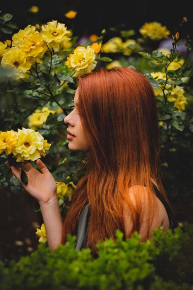 Redhead model with sunflowers. Photo by DP Fotographo/Pexels.