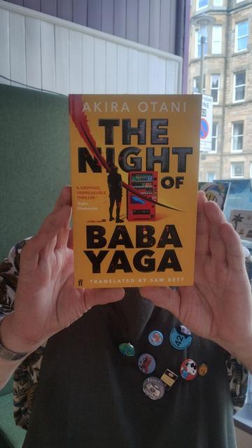 Bookseller Joe holding up a copy of Otani's The Night of the Baba Yaga, in the Edinburgh Bookshop
