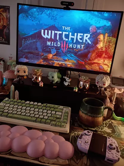 This is a picture of my gaming desk with pink and green accents and The Witcher 3 on the monitor.