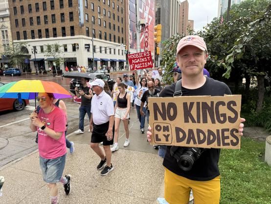 An image of me at the No Kings protest in Indianapolis, Indiana holding a sign that reads, “No Kings Only Daddies.”